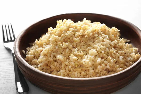 Порция коричневого риса в декоративной деревянной тарелке — стоковое фото