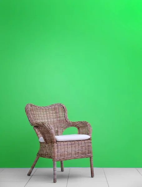 Wicker stol mod grøn væg - Stock-foto