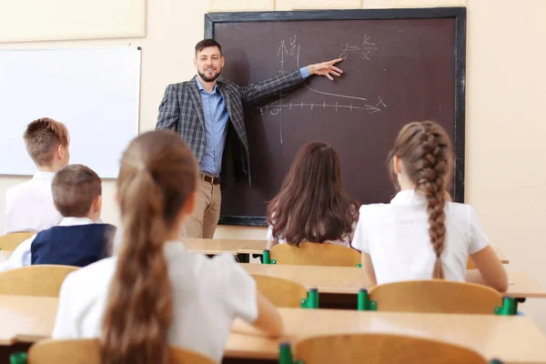 Alumnos escuchando al profesor en el aula —  Fotos de Stock