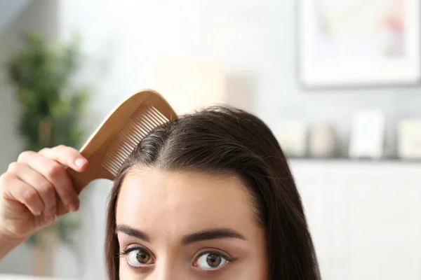 Молода жінка розчісує волосся — стокове фото