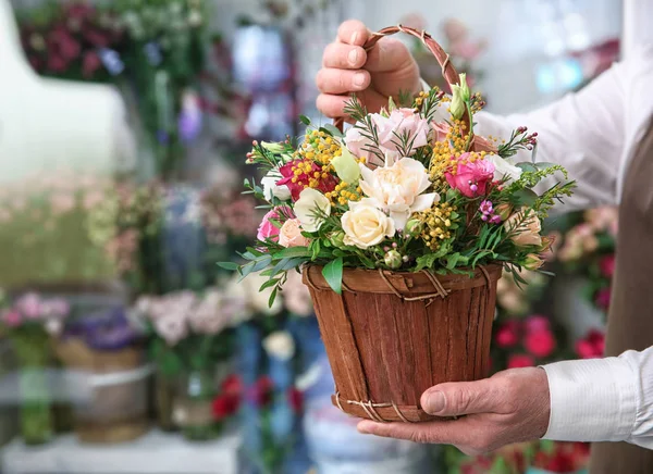 Floristería masculina sosteniendo cesta con flores — Foto de Stock