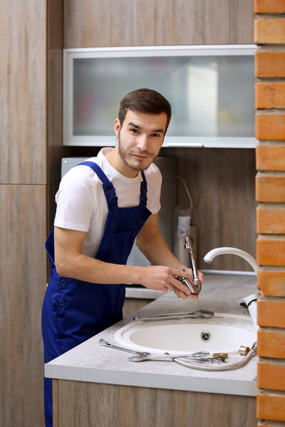 Handsome plumber in kitchen