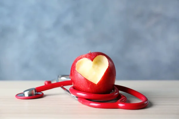 Pomme avec coupe en forme de cœur et stéthoscope — Photo