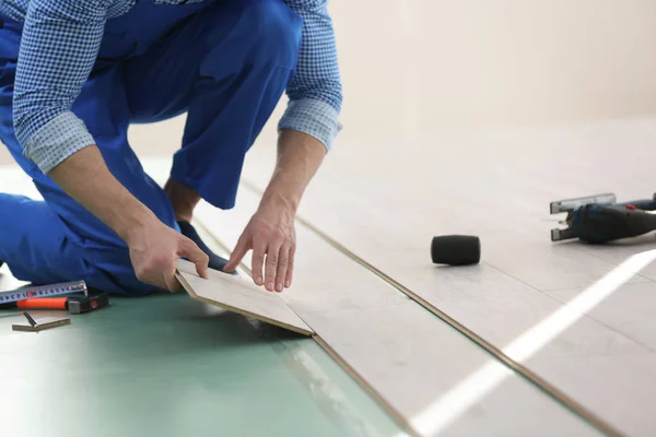 Maschio mani operaio installazione pavimenti in laminato — Foto Stock