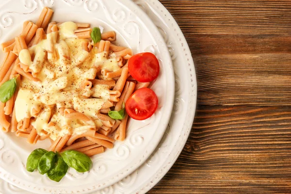 Portion leckere Pasta mit Käse auf Holzgrund — Stockfoto