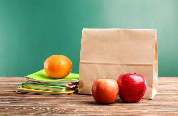Lunch bag on wooden tabletop against chalkboard background — Stock Photo, Image