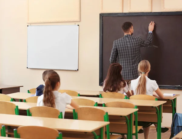 Alumnos escuchando al profesor en el aula — Foto de Stock