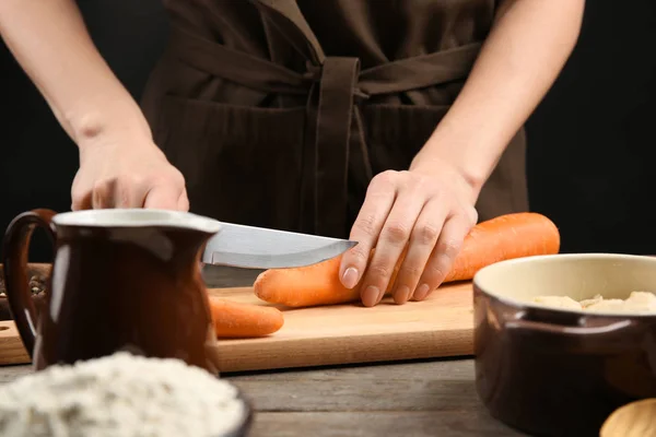 Mãos femininas cortando cenoura — Fotografia de Stock