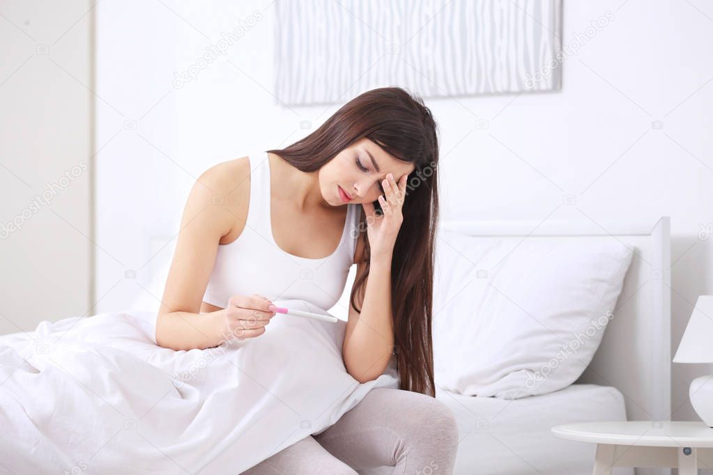  woman looking at pregnancy test