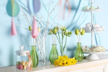 Paskalya sembolleri ve şöminenin üzerinde çiçekler ile muamele etmek 