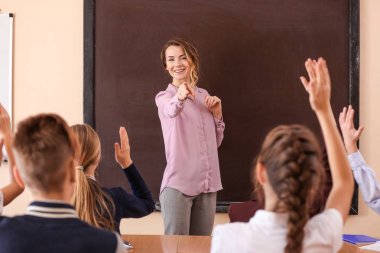 Öğretmen dinleme ve eller yükselterek öğrencilerin sınıfta cevap