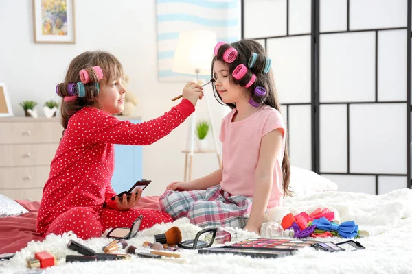 Cute little girls playing with their mother's stuff on bed — Stock Photo, Image