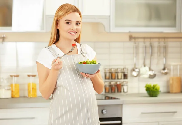 Беременная женщина держит миску с салатом — стоковое фото