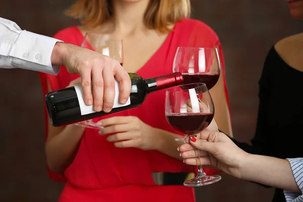 Servitören som serverar vin till kvinnor — Stockfoto