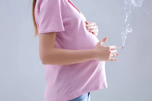 Těhotná žena kouření cigaret — Stock fotografie