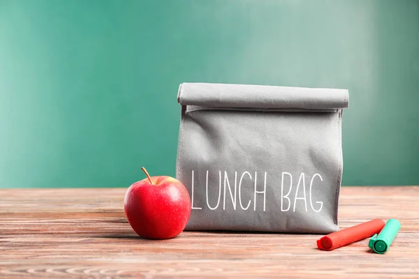 Borsa da pranzo su tavolo in legno sullo sfondo della lavagna — Foto Stock