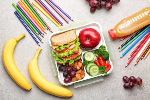 Delicious food and colorful pencils on light textured background — Stock Photo, Image