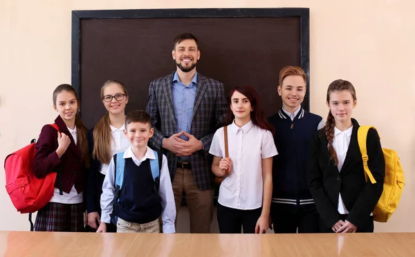 Leerlingen met lerares bij schoolbord in de klas — Stockfoto