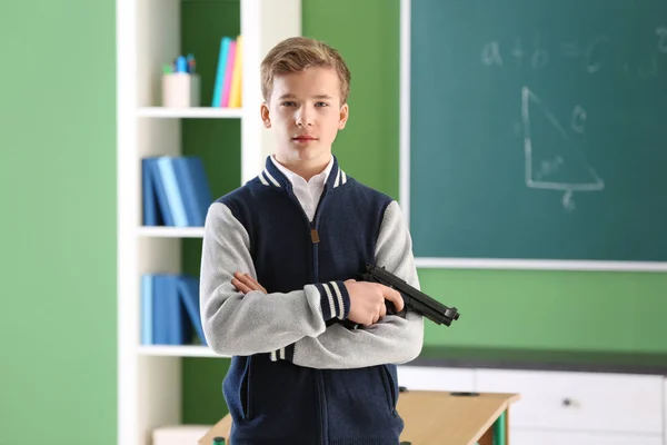 Мальчик-подросток с пистолетом в классе — стоковое фото