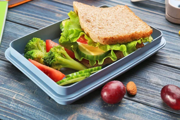 Lunch box z pysznego jedzenia na podłoże drewniane — Zdjęcie stockowe