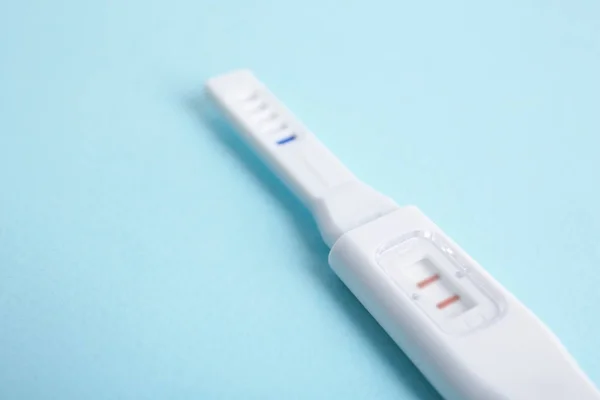 Pregnancy test on turquoise table — Stock Photo, Image