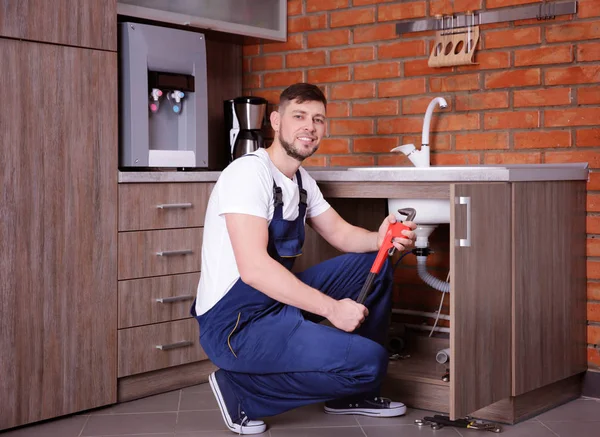 Plumber repairing sink pipes