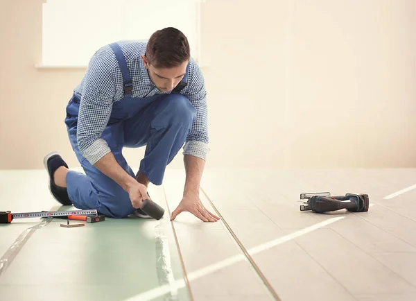 Worker installing laminate flooring — Stock Photo, Image