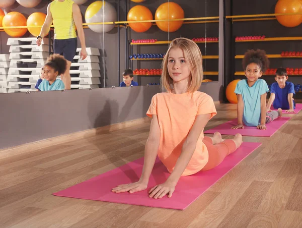 Los niños en la lección de educación física en el gimnasio escolar —  Fotos de Stock