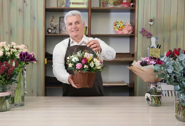 Florist holding basket with flowers — Stock Photo, Image