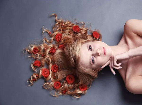 Mujer joven con flores en el pelo — Foto de Stock