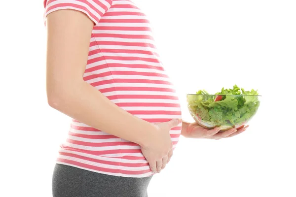 Gravid kvinna anläggning skål med sallad — Stockfoto
