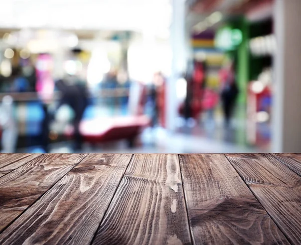 Dřevěný stůl na rozmazané shopping mall — Stock fotografie