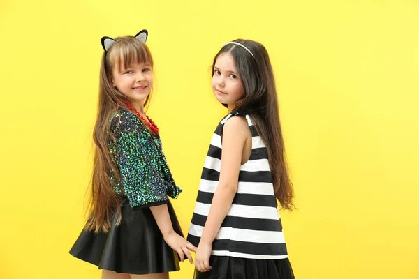 Meninas bonitos se divertindo no fundo amarelo — Fotografia de Stock