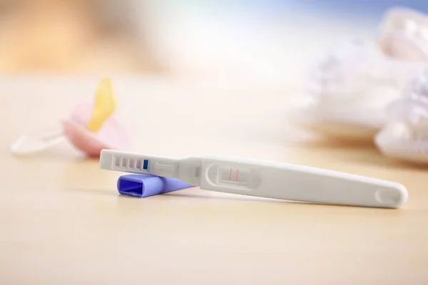 Teste de gravidez e chupeta de bebê — Fotografia de Stock