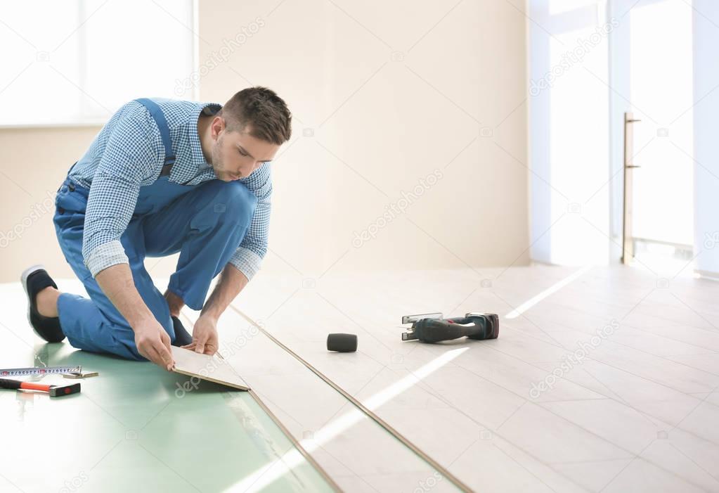 worker installing laminate flooring