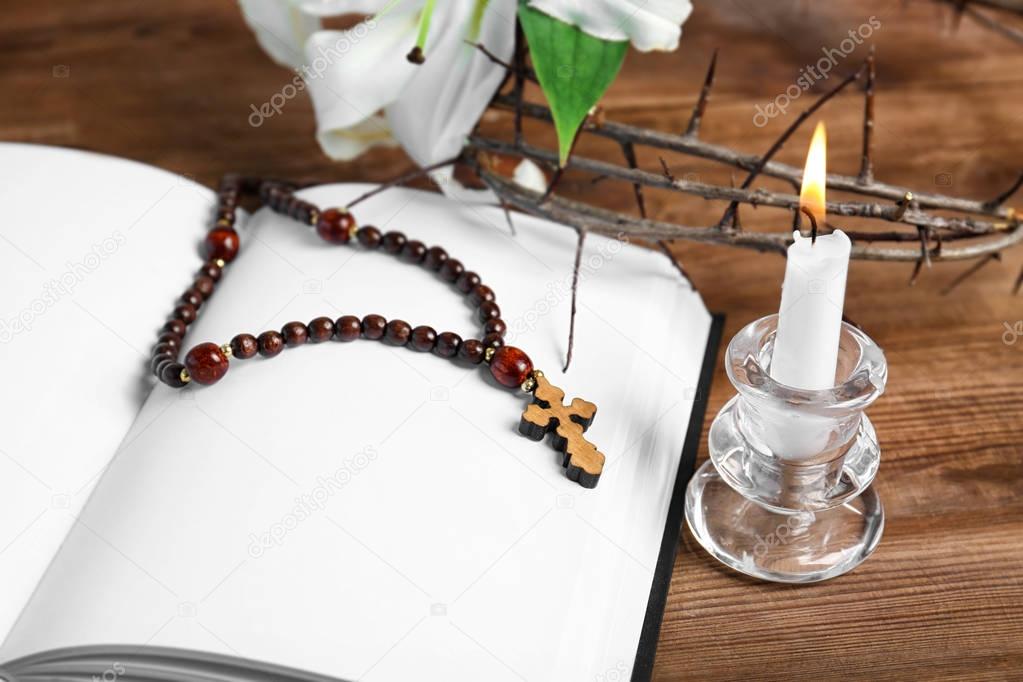 book, candle, rosary and crown of thorns
