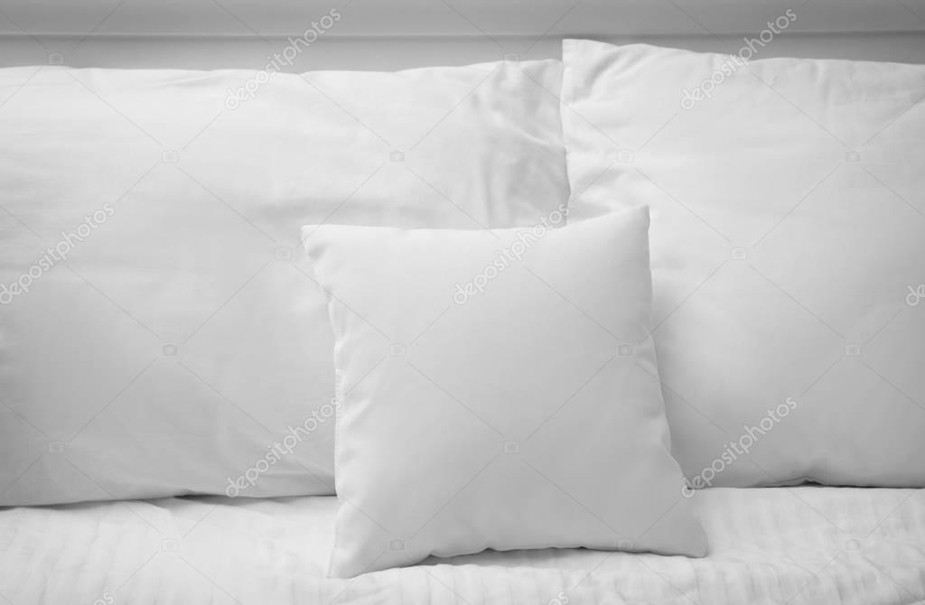 Blank soft pillows on bed