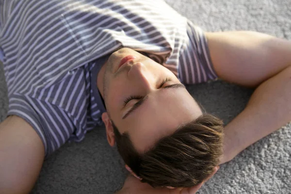 Young man lying on soft floor — Stock Photo, Image