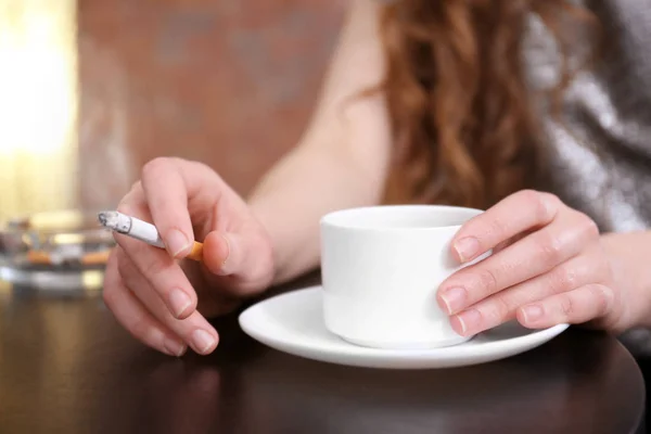 Hands holding cigarette and cup of coffee — Stock Photo, Image