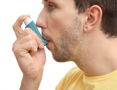 Astım ilacı kullanan genç adam 