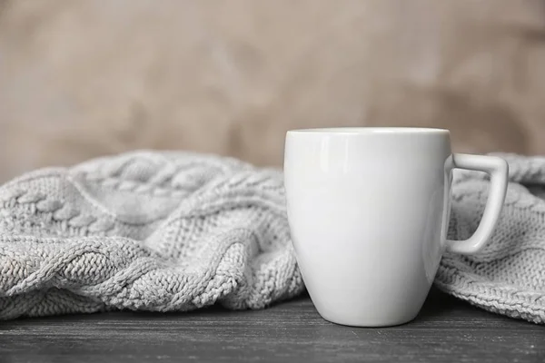 White cup and knitted scarf — Stock Photo, Image