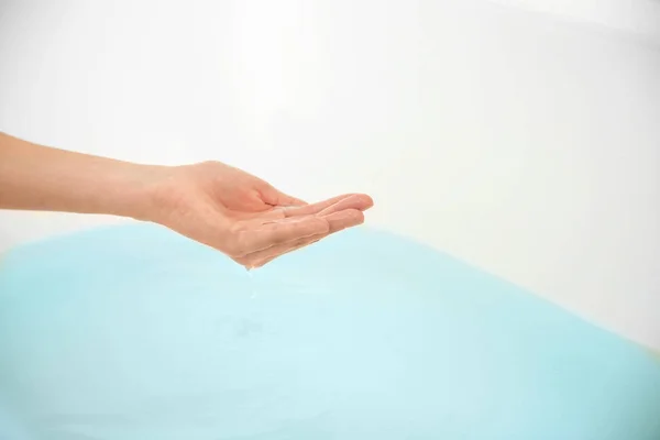 Mano femenina que determina la temperatura del agua — Foto de Stock