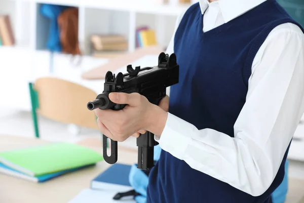 Schoolboy holding machine gun — Stock Photo, Image