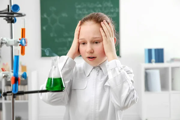 School girl looking at flask — Stock Photo, Image