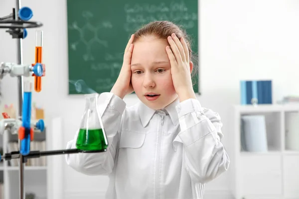 Ragazza della scuola guardando fiaschetta — Foto Stock