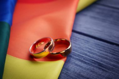 İki alyans ve gökkuşağı homoseksüel bayrağı 