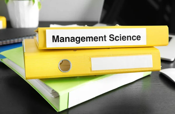 Folder with label MANAGEMENT SCIENCE on wooden table