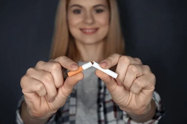 Vista de cerca de la mujer rompiendo cigarrillo en las manos — Foto de Stock