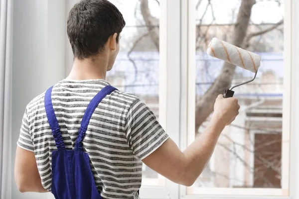 Молодий працівник малює вікно — стокове фото
