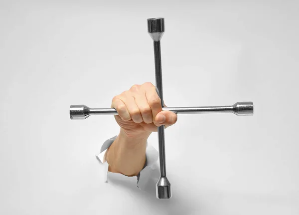 Hand van automonteur met wiel moersleutel — Stockfoto